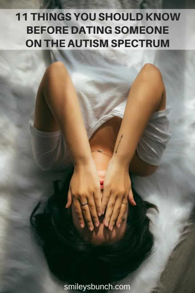 Woman with autism on bed covering her face with hands