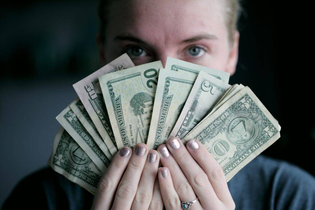 woman holding money: affiliate marketing tips