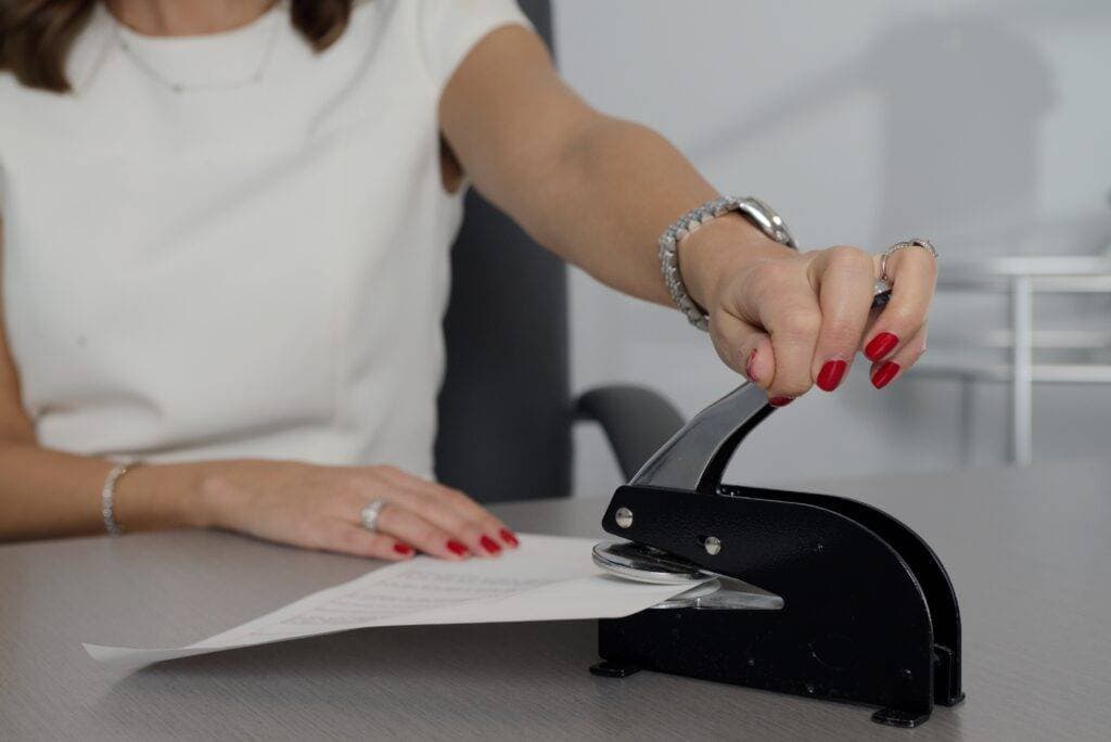 woman using a notary seal on a document